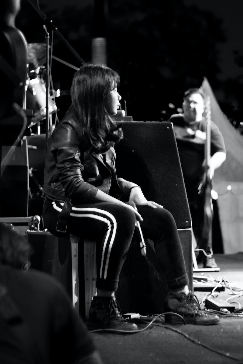 grayscale photography of woman sitting on box